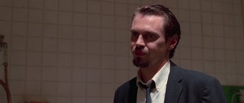 Movie still from “Reservoir Dogs” (1992), directed by Quentin Tarantino – A person wearing a suit and tie; Close Up shot, Low angle