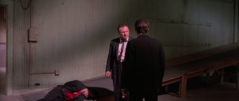 Movie still from “Reservoir Dogs” (1992), directed by Quentin Tarantino – Two men in business suits talking to each other; Wide shot, Over the shoulder angle