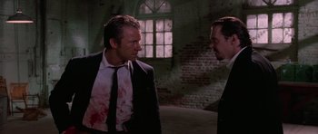 Movie still from “Reservoir Dogs” (1992), directed by Quentin Tarantino – Two men in suits with blood on their hands; Medium shot, Over the shoulder angle