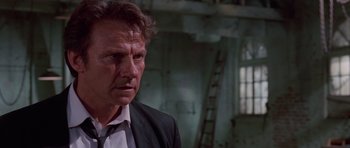 Movie still from “Reservoir Dogs” (1992), directed by Quentin Tarantino – A person wearing a suit and tie; Close Up shot, Low angle