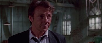 Movie still from “Reservoir Dogs” (1992), directed by Quentin Tarantino – A person wearing a suit and tie; Close Up shot, Low angle