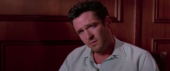 Movie still from “Reservoir Dogs” (1992), directed by Quentin Tarantino – A person wearing a green shirt; Close Up shot, High angle