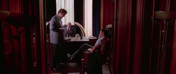 Movie still from “Reservoir Dogs” (1992), directed by Quentin Tarantino – Three men sitting at a table in a room; Wide shot, Low angle