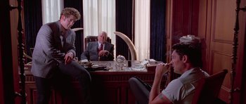 Movie still from “Reservoir Dogs” (1992), directed by Quentin Tarantino – Three men sitting at a desk in a room; Wide shot, Low angle