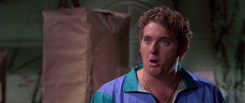 Movie still from “Reservoir Dogs” (1992), directed by Quentin Tarantino – A person wearing a jacket and looking surprised; Close Up shot, Low angle