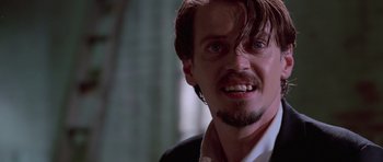 Movie still from “Reservoir Dogs” (1992), directed by Quentin Tarantino – A person wearing a suit and tie; Close Up shot, Low angle