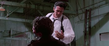 Movie still from “Reservoir Dogs” (1992), directed by Quentin Tarantino – A man in a white dress shirt and a black neck tie; Medium shot, Over the shoulder angle