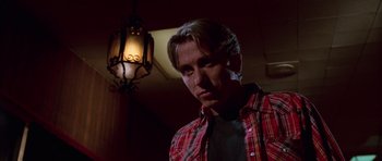 Movie still from “Reservoir Dogs” (1992), directed by Quentin Tarantino – A man in a red and black plaid shirt is looking down; Close Up shot, Low angle