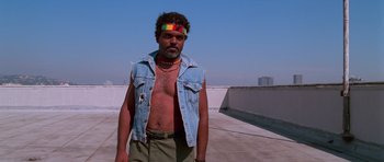 Movie still from “Reservoir Dogs” (1992), directed by Quentin Tarantino – A man with a beard wearing a jean vest; Medium shot, Low angle