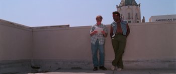 Movie still from “Reservoir Dogs” (1992), directed by Quentin Tarantino – Two men standing next to each other near a wall; Wide shot, Low angle
