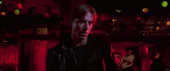 Movie still from “Reservoir Dogs” (1992), directed by Quentin Tarantino – A man in a leather jacket standing in a dark room; Close Up shot, Low angle