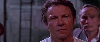 Movie still from “Reservoir Dogs” (1992), directed by Quentin Tarantino – A person wearing a white t - shirt; Close Up shot, Low angle