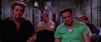 Movie still from “Reservoir Dogs” (1992), directed by Quentin Tarantino – A group of men standing next to each other in a room; Medium shot, Low angle