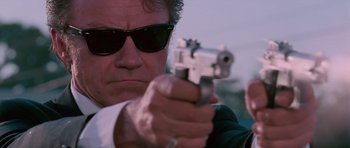 Movie still from “Reservoir Dogs” (1992), directed by Quentin Tarantino – A person holding a gun; Close Up shot, Low angle