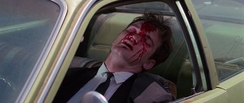 Movie still from “Reservoir Dogs” (1992), directed by Quentin Tarantino – A man in a suit with blood on his face; Close Up shot, Low angle