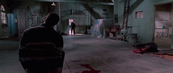 Movie still from “Reservoir Dogs” (1992), directed by Quentin Tarantino – A man standing in an empty room next to a table; Wide shot, High angle