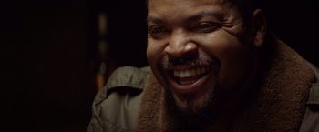Movie still from “Ride Along” (2014), directed by Tim Story – A person with a beard smiling; Close Up shot, Over the shoulder angle