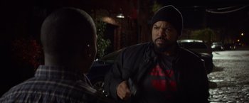 Movie still from “Ride Along” (2014), directed by Tim Story – A man in a black jacket is talking to another man; Medium shot, Over the shoulder angle