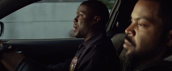 Movie still from “Ride Along” (2014), directed by Tim Story – A man sitting in the driver's seat of a car; Close Up shot, Over the shoulder angle