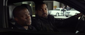 Movie still from “Ride Along” (2014), directed by Tim Story – Two men in the back seat of a car; Close Up shot, Over the shoulder angle