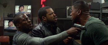 Movie still from “Ride Along” (2014), directed by Tim Story – Two men are fighting in front of a neon sign; Close Up shot, Over the shoulder angle
