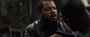 Movie still from “Ride Along” (2014), directed by Tim Story – A man in a leather jacket holding a cell phone; Close Up shot, Over the shoulder angle