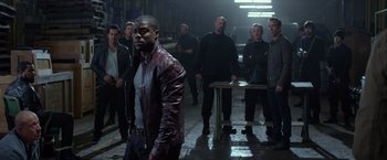 Movie still from “Ride Along” (2014), directed by Tim Story – A group of men standing in a room; Medium shot, Over the shoulder angle
