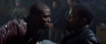 Movie still from “Ride Along” (2014), directed by Tim Story – Two black men face each other in a dark room; Medium shot, Over the shoulder angle