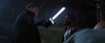 Movie still from “Ride Along” (2014), directed by Tim Story – A man is holding a sword in his hand and another man is holding a knife in his other hand; Medium shot, Over the shoulder angle