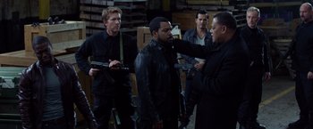 Movie still from “Ride Along” (2014), directed by Tim Story – A group of men standing next to each other in a room; Medium shot, Over the shoulder angle
