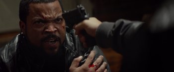 Movie still from “Ride Along” (2014), directed by Tim Story – A man is holding a gun up to his face; Close Up shot, Over the shoulder angle