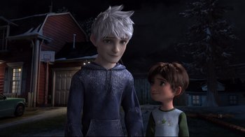 Movie still from “Rise of the Guardians” (2012), directed by Peter Ramsey – Two animated characters standing next to each other in front of a building; Medium shot, Over the shoulder angle