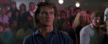 Movie still from “Road House” (1989), directed by Rowdy Herrington – A person with long hair; Close Up shot, Low angle