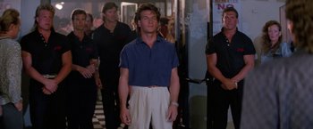 Movie still from “Road House” (1989), directed by Rowdy Herrington – A man standing in front of other men; Medium shot, Low angle