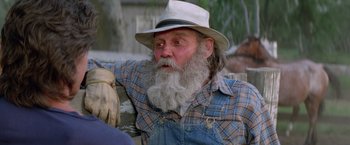 Movie still from “Road House” (1989), directed by Rowdy Herrington – An older man with a beard and a hat; Close Up shot, Over the shoulder angle