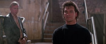 Movie still from “Road House” (1989), directed by Rowdy Herrington – A person wearing a black t - shirt; Close Up shot, Low angle