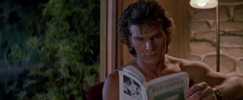 Movie still from “Road House” (1989), directed by Rowdy Herrington – A man sitting in front of a window reading a newspaper; Close Up shot, Over the shoulder angle