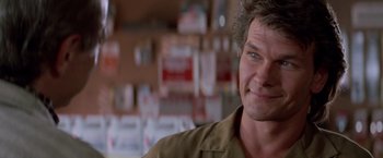 Movie still from “Road House” (1989), directed by Rowdy Herrington – A person wearing a brown shirt; Close Up shot, Over the shoulder angle