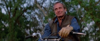 Movie still from “Road House” (1989), directed by Rowdy Herrington – A person riding a bike; Close Up shot, Low angle