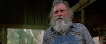 Movie still from “Road House” (1989), directed by Rowdy Herrington – An old man with a beard and a blue overalls; Close Up shot, Low angle