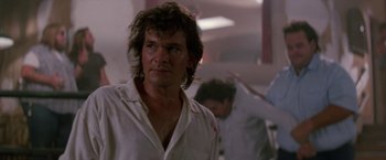 Movie still from “Road House” (1989), directed by Rowdy Herrington – A person wearing a white shirt; Close Up shot, Low angle