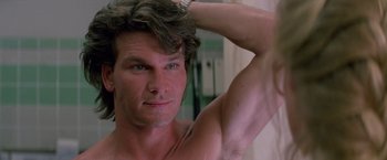 Movie still from “Road House” (1989), directed by Rowdy Herrington – A person in a mirror with his arms up; Close Up shot, Over the shoulder angle