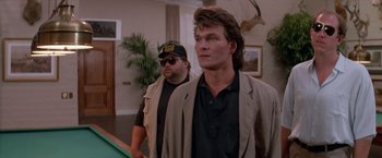 Movie still from “Road House” (1989), directed by Rowdy Herrington – Two men standing next to each other in a room; Medium shot, Over the shoulder angle