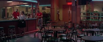 Movie still from “Road House” (1989), directed by Rowdy Herrington – A man standing at a counter in a restaurant; Wide shot, High angle