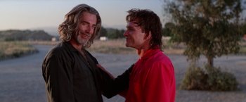 Movie still from “Road House” (1989), directed by Rowdy Herrington – Two men standing next to each other on a beach; Close Up shot, Low angle