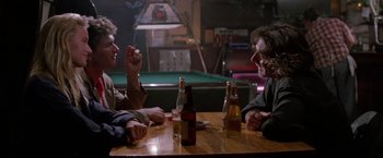 Movie still from “Road House” (1989), directed by Rowdy Herrington – Two men sitting at a table with drinks and a pool table in the background; Medium shot, Over the shoulder angle