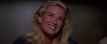 Movie still from “Road House” (1989), directed by Rowdy Herrington – A person with blonde hair smiling; Close Up shot, Low angle
