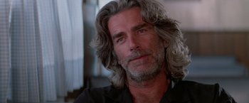Movie still from “Road House” (1989), directed by Rowdy Herrington – A person with long grey hair; Close Up shot, Low angle