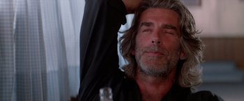 Movie still from “Road House” (1989), directed by Rowdy Herrington – A person with long grey hair; Close Up shot, Low angle