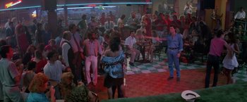 Movie still from “Road House” (1989), directed by Rowdy Herrington – A group of people are gathered in a bar; Wide shot, High angle